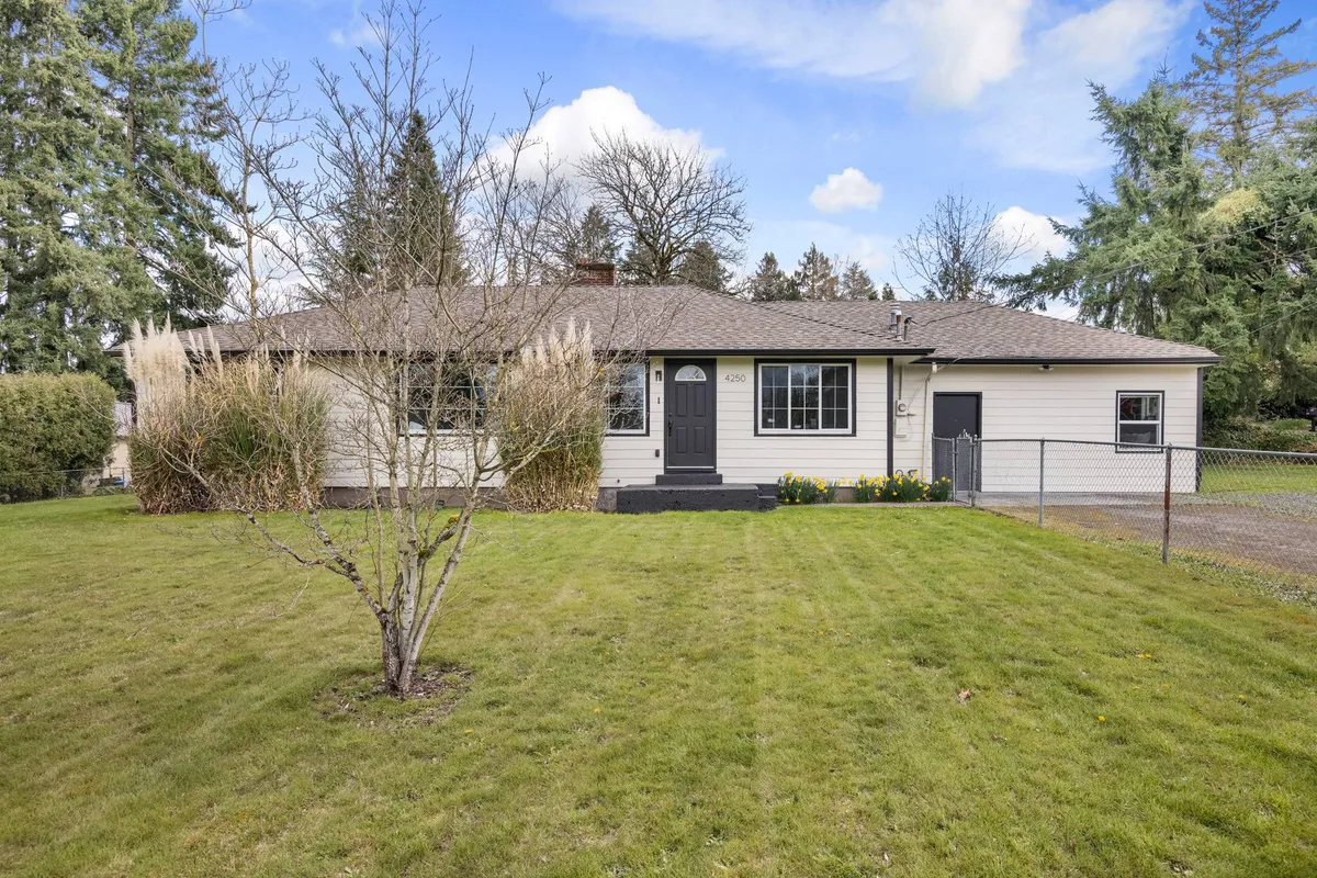 A welcoming view of the front porch surrounded by a lush green lawn and vibrant flower beds, all enclosed by a secure fence. The setup is perfect for families and children to enjoy outdoor play and gatherings in a safe environment.