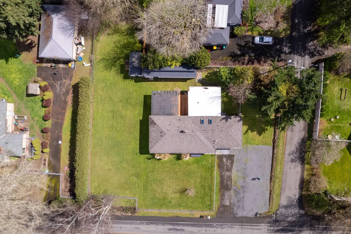 The main house stands amidst beautiful greenery, with a driveway and ample open yard space. The area is suitable for hosting barbecues, children’s games, and casual outdoor gatherings, enhanced by natural shade from surrounding trees.